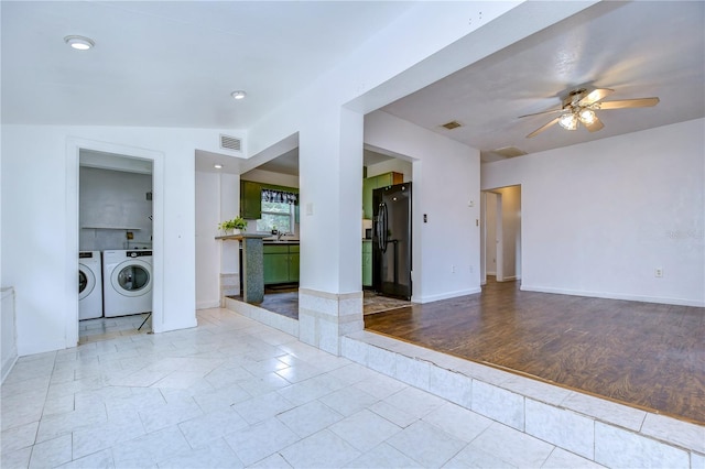 empty room with vaulted ceiling, light hardwood / wood-style flooring, ceiling fan, and washing machine and clothes dryer