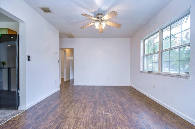 spare room with dark hardwood / wood-style floors and ceiling fan