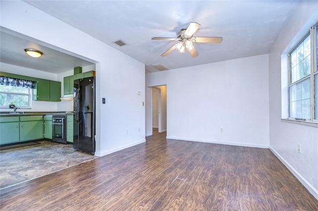 unfurnished living room featuring ceiling fan, dark hardwood / wood-style flooring, and sink