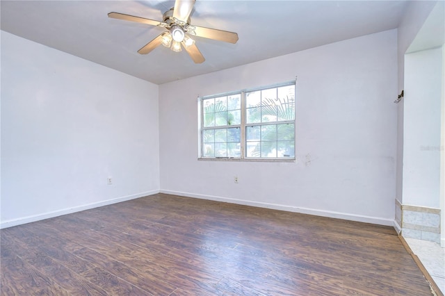 spare room featuring ceiling fan and dark wood-type flooring