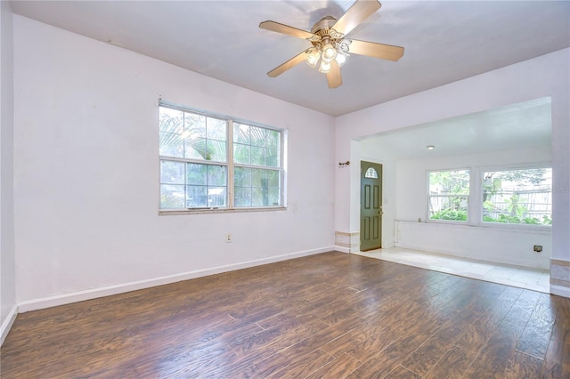 spare room with ceiling fan, a healthy amount of sunlight, and dark hardwood / wood-style floors