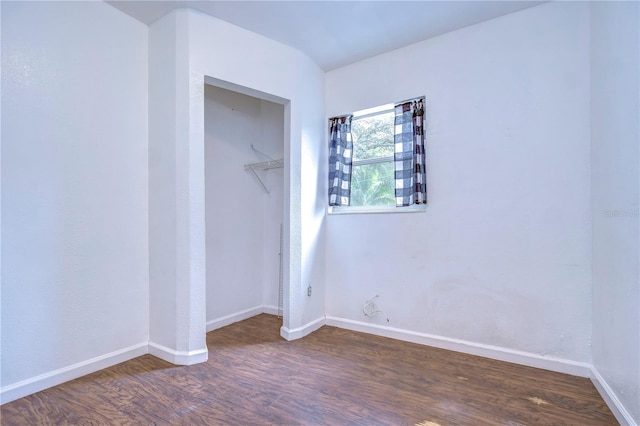 unfurnished bedroom featuring dark hardwood / wood-style floors and a closet