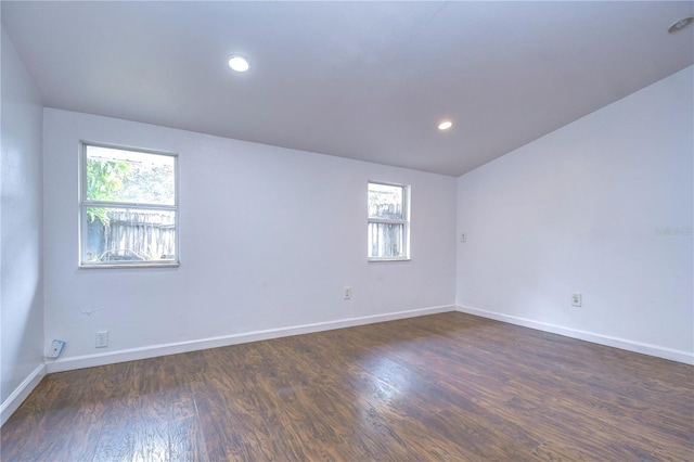 unfurnished room with dark hardwood / wood-style flooring and lofted ceiling