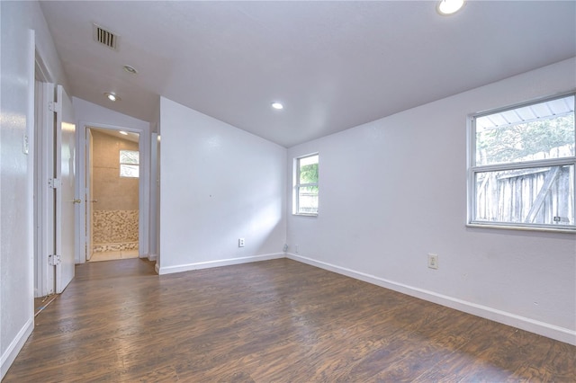 empty room with dark hardwood / wood-style flooring and lofted ceiling