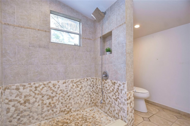 bathroom with tile patterned floors, toilet, lofted ceiling, and tiled shower