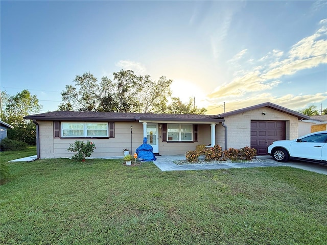 ranch-style house with a garage and a yard