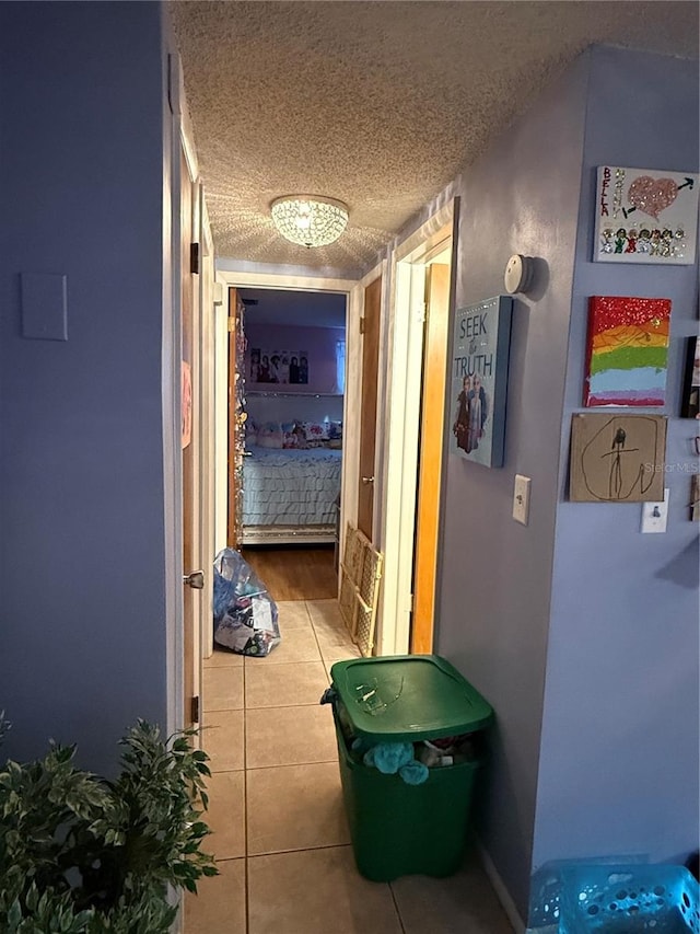 hallway with tile patterned flooring and a textured ceiling