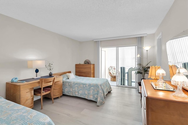 bedroom featuring light wood-type flooring and a textured ceiling