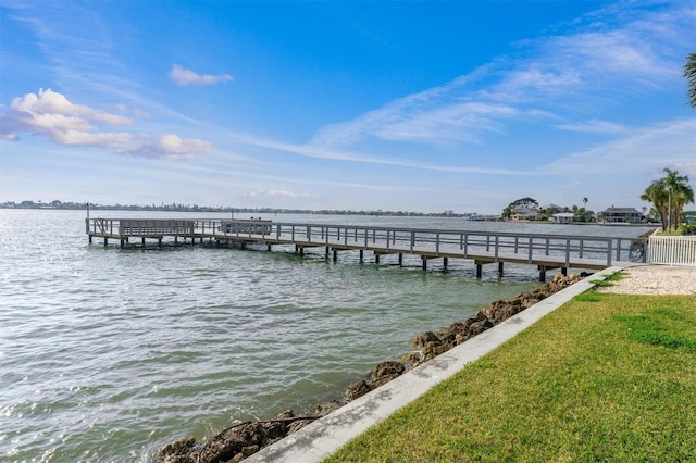 view of dock with a yard and a water view