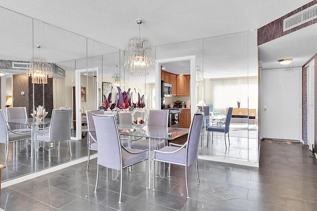 4575 Cove Cir Unit 202, Saint Petersburg, FL 33708 - dining space with a chandelier, a textured ceiling, and dark tile patterned flooring