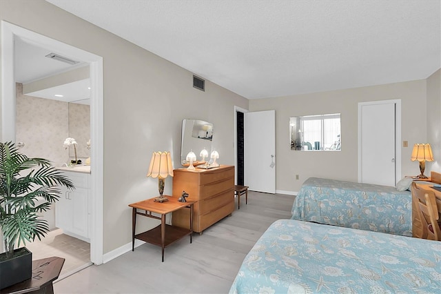 bedroom with a textured ceiling and light wood-type flooring