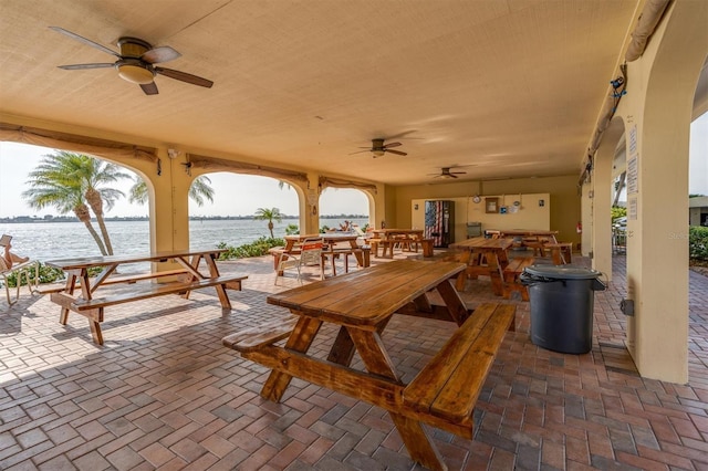 view of patio / terrace with ceiling fan and a water view