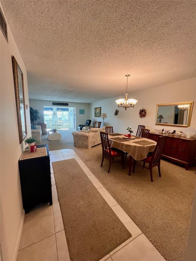 dining area featuring a chandelier, a textured ceiling, and tile patterned floors