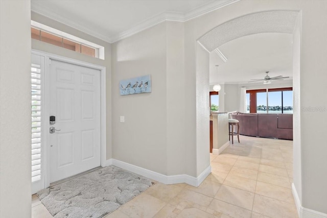 entrance foyer with ceiling fan and crown molding