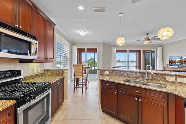 kitchen with hanging light fixtures, sink, a healthy amount of sunlight, and appliances with stainless steel finishes