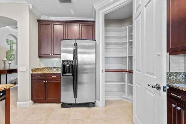 kitchen with decorative backsplash, ornamental molding, light tile patterned flooring, light stone counters, and stainless steel fridge with ice dispenser