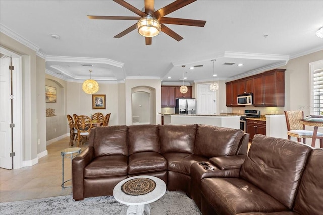 tiled living room with ceiling fan and ornamental molding