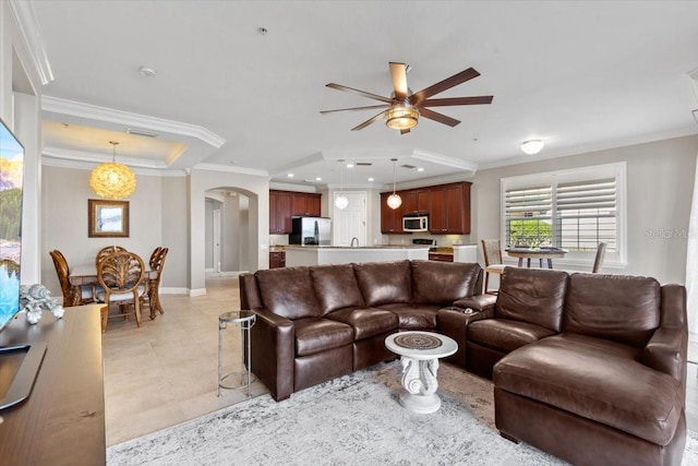 living room with light tile patterned floors, ceiling fan, and crown molding