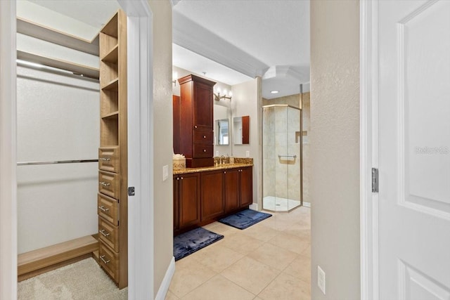 bathroom with tile patterned flooring, vanity, and a shower with door