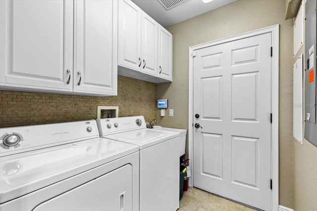 washroom with washing machine and clothes dryer, light tile patterned flooring, and cabinets