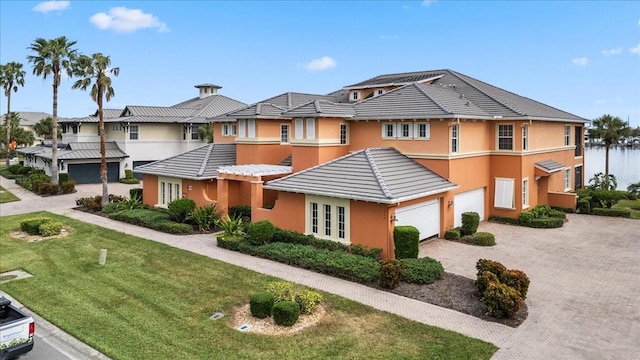 multi unit property featuring a front yard and a garage