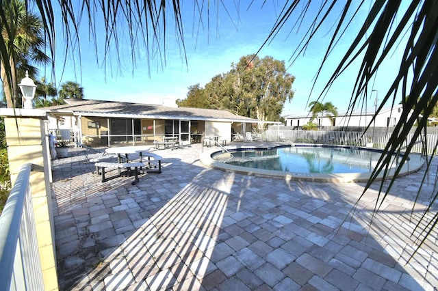 view of pool with a sunroom and a patio