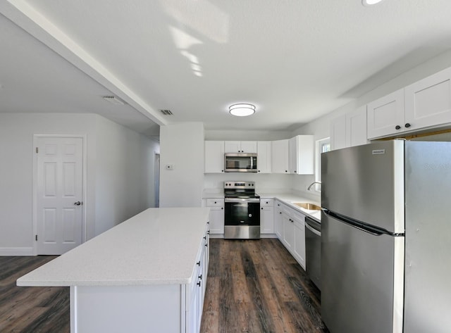 kitchen with white cabinets, a kitchen island, dark hardwood / wood-style flooring, and stainless steel appliances