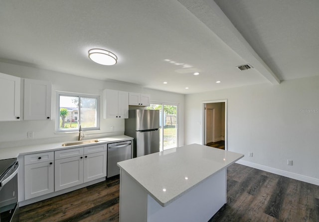 kitchen featuring a wealth of natural light, white cabinetry, sink, a kitchen island, and appliances with stainless steel finishes