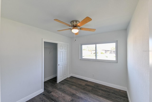 unfurnished bedroom featuring ceiling fan, dark hardwood / wood-style flooring, and a closet