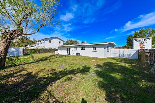 back of house with a lawn and central AC unit