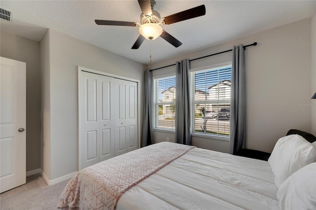 bedroom with light carpet, a closet, and ceiling fan