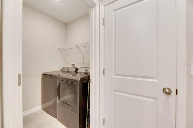 clothes washing area with light tile patterned flooring and independent washer and dryer