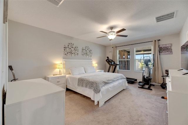 carpeted bedroom featuring ceiling fan and a textured ceiling