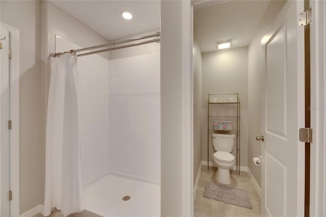 bathroom with a shower with shower curtain, toilet, and tile patterned floors