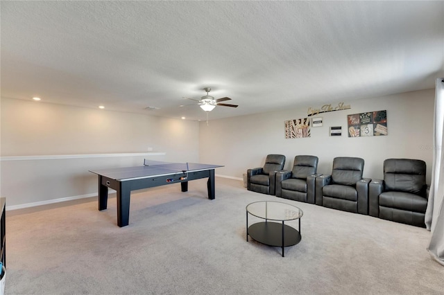 game room featuring ceiling fan, light colored carpet, and a textured ceiling