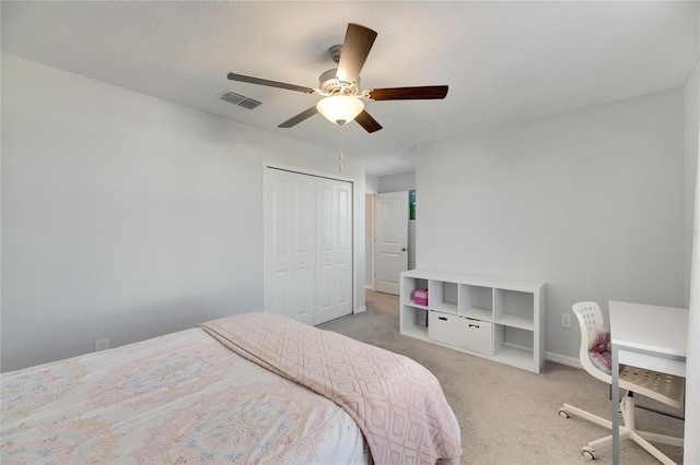 carpeted bedroom featuring ceiling fan and a closet