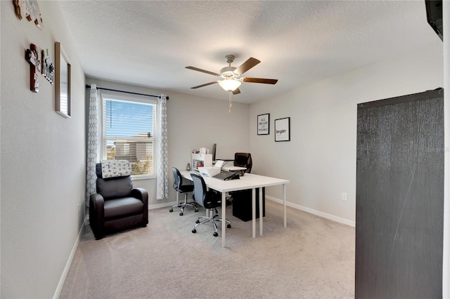 carpeted office featuring a textured ceiling and ceiling fan