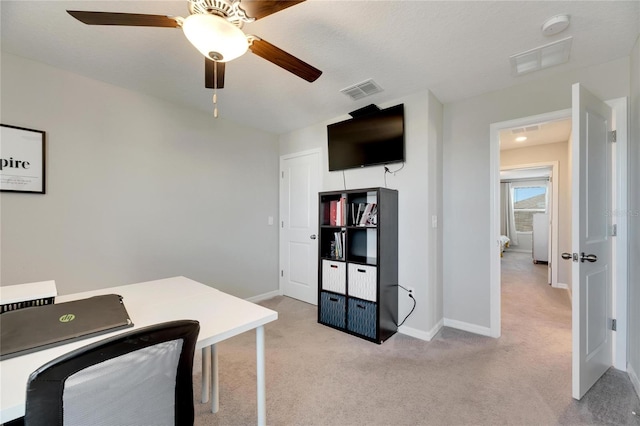 office space with a textured ceiling, light colored carpet, and ceiling fan