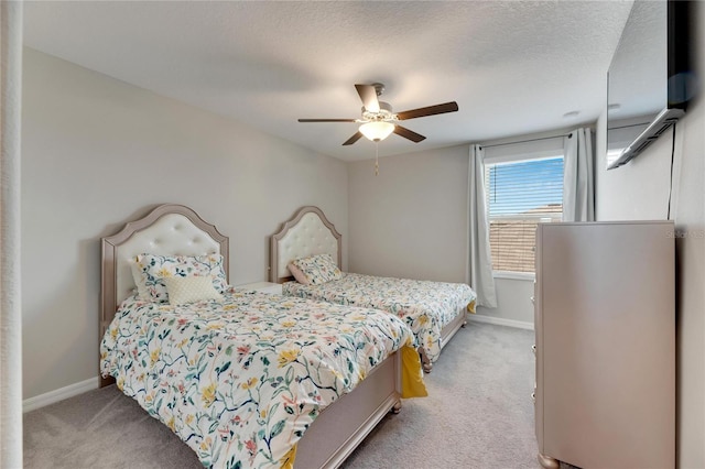 carpeted bedroom featuring ceiling fan and a textured ceiling