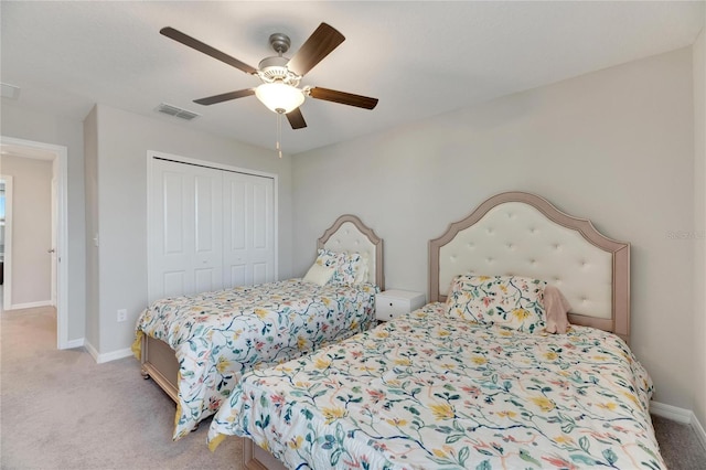 bedroom with a closet, ceiling fan, and light colored carpet