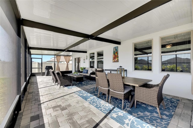 sunroom featuring beamed ceiling