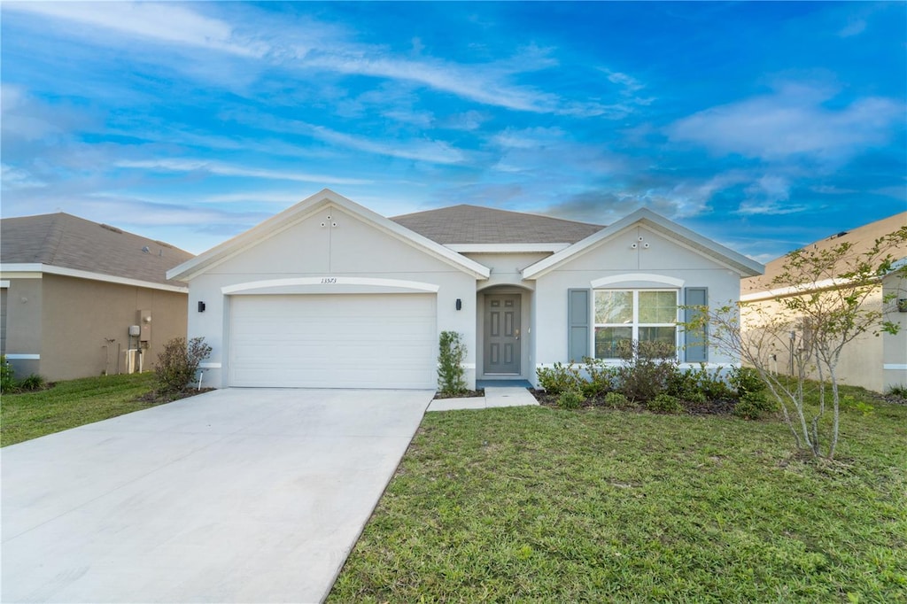 single story home with a garage and a front lawn