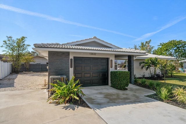 view of front of house featuring a garage and central air condition unit