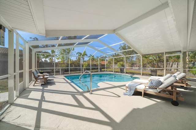 view of swimming pool featuring glass enclosure and a patio