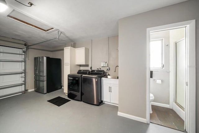 washroom with washing machine and clothes dryer, sink, and cabinets