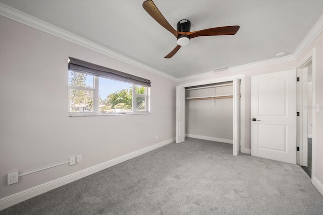 unfurnished bedroom featuring carpet flooring, a closet, ceiling fan, and crown molding