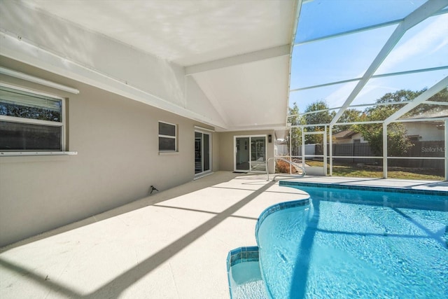 view of swimming pool with glass enclosure and a patio