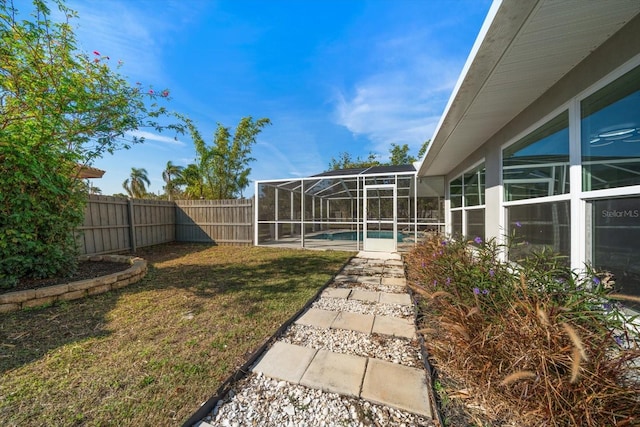 view of yard with a fenced in pool and a lanai