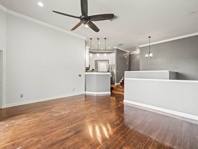 unfurnished living room with ceiling fan with notable chandelier, dark hardwood / wood-style flooring, and crown molding