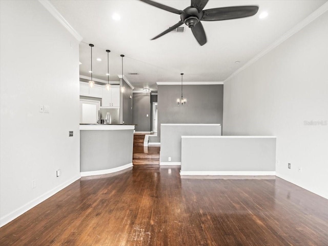 unfurnished living room featuring crown molding, dark hardwood / wood-style flooring, and ceiling fan with notable chandelier